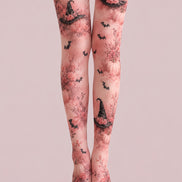 A pair of sheer pink tights with a Halloween-themed print featuring black witch hats, bats, and pumpkins, shown on a model's legs against a solid pale pink background.